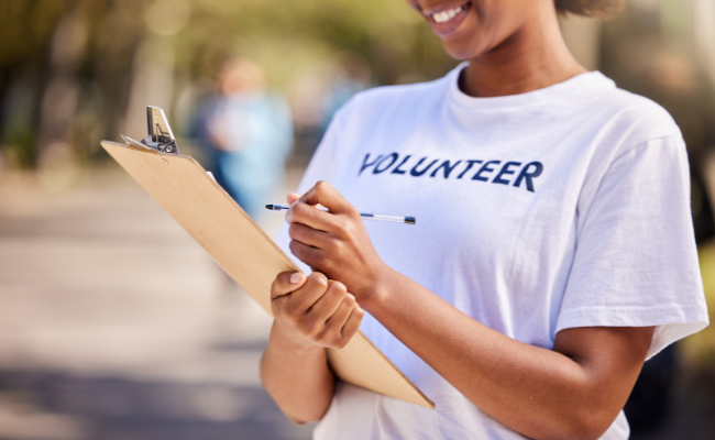 woman holds clipboard with volunteer t-shirt